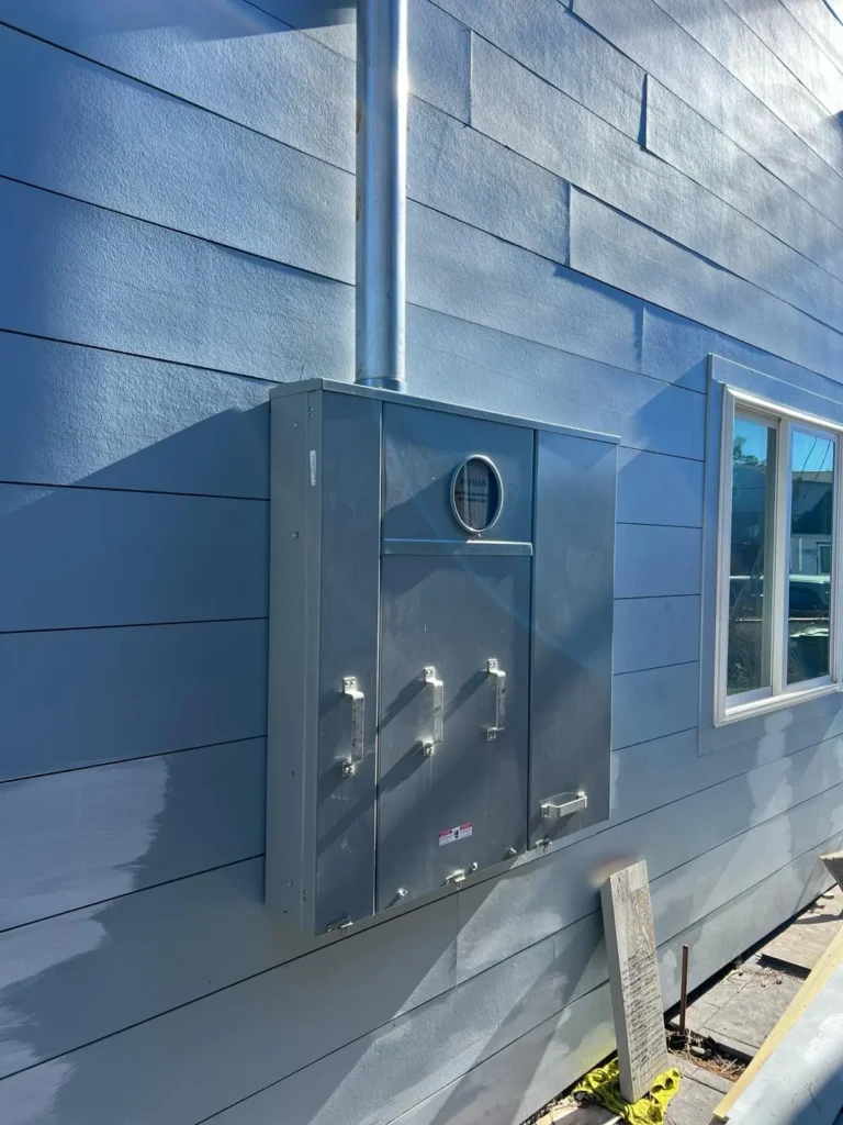 A water heater on the side of a house.